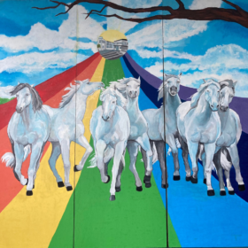Cavalli bianchi su un arcobaleno. Sullo sfondo il disegno della scuola media all'interno di uno cerchio